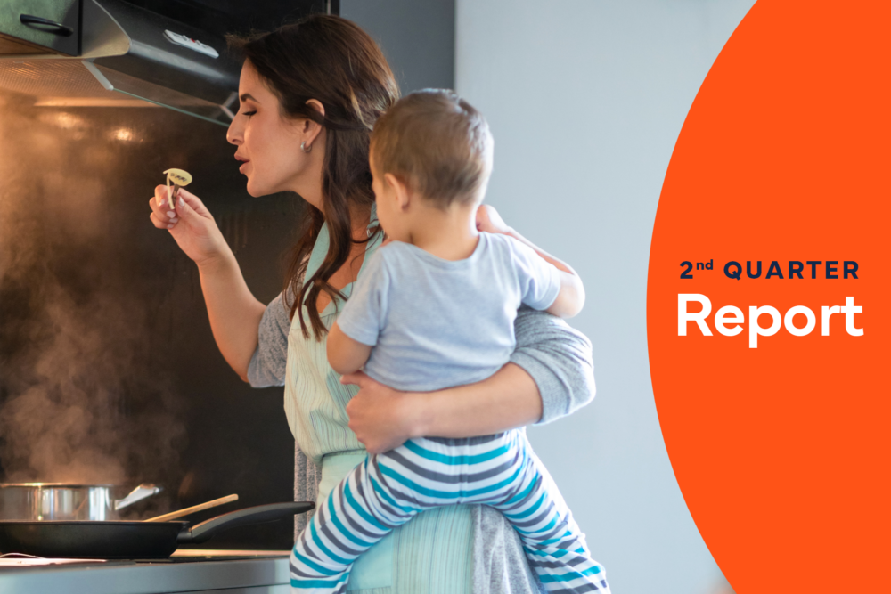 parent holding child while cooking at induction stove, cover of 2023 2nd quarter report