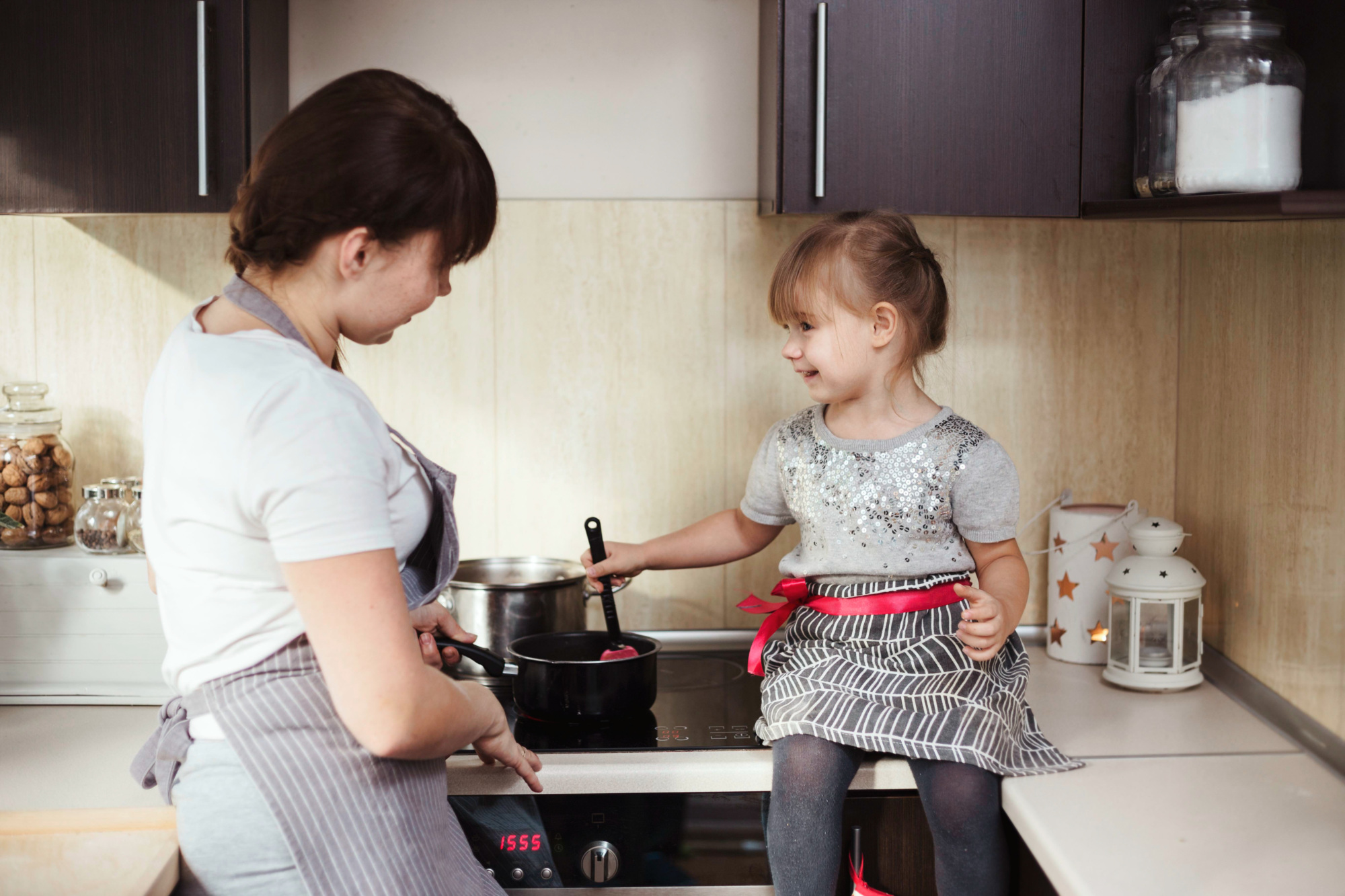mother and daughter cooking on induction stove