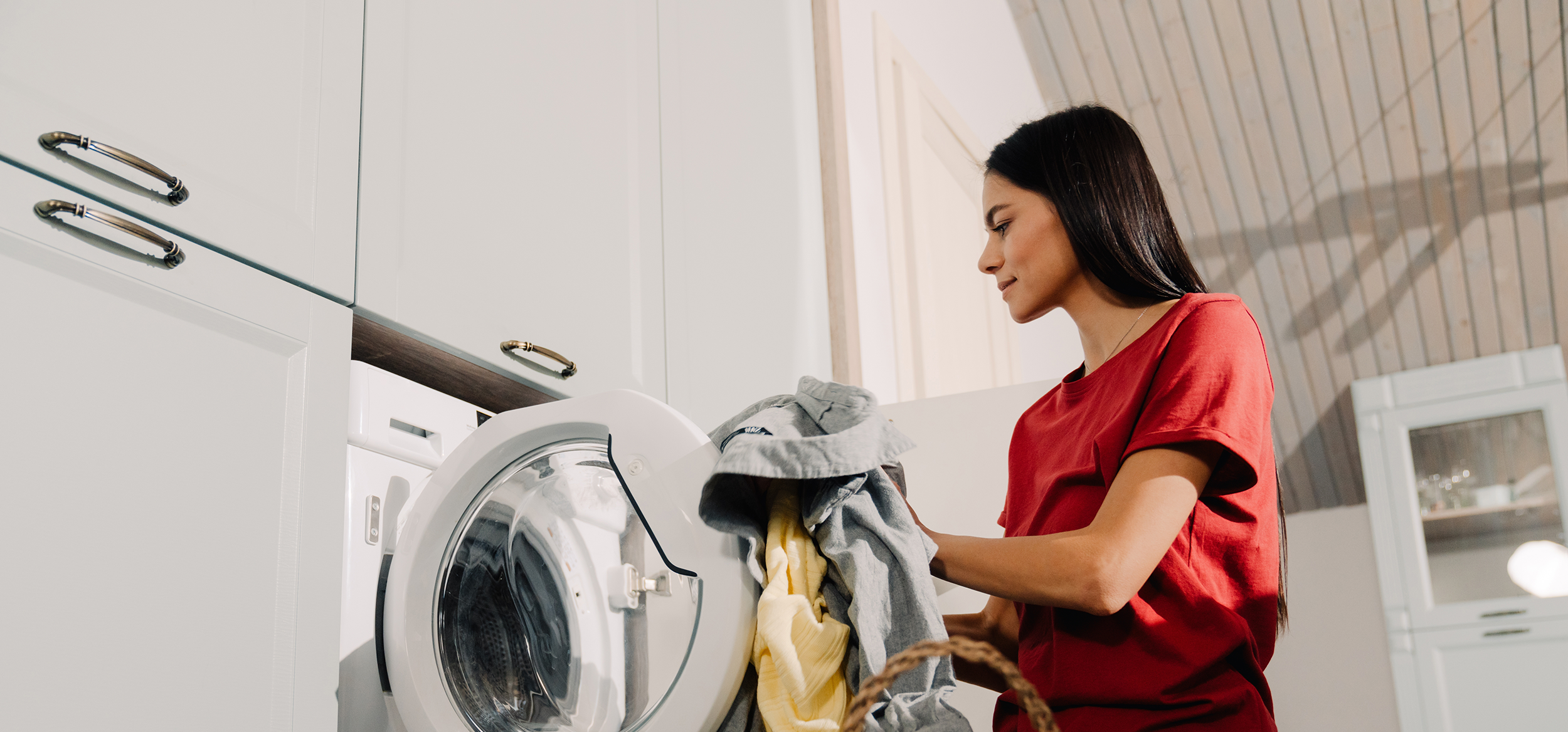 Woman doing laundry in a front-loading washing machine